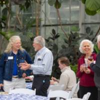 Two groups of two colleagues standing by each other, chatting